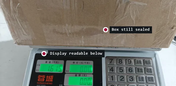 Sealed cardboard parcel resting on a digital parcel scale with a green display reading 1.615
