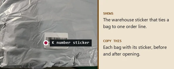 Grey plastic bag with a white order sticker whose number starts with K, the rest blurred